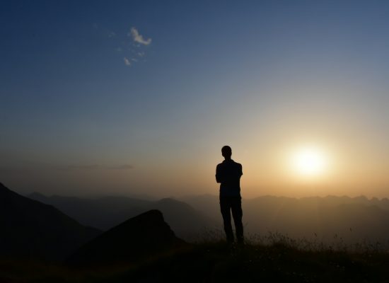 Business leader overlooking a vast landscape at sunrise, representing strategic AI perspective